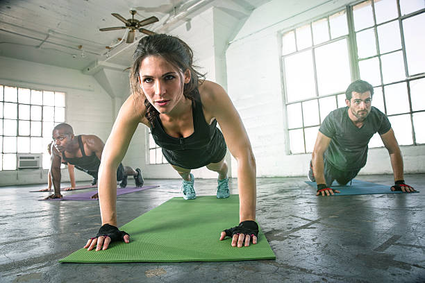 Female leads  power yoga group class strength determination stock photo