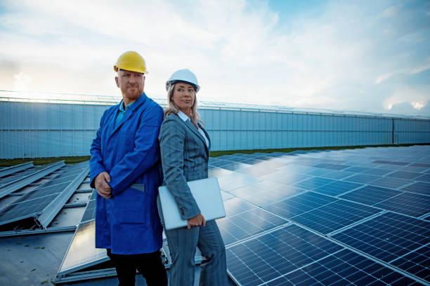 A female manager engineer at a solar panel site with a male technician stock photo