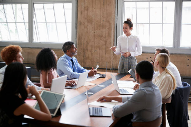 Female manager stands addressing team at board meeting  business meeting stock pictures, royalty-free photos & images