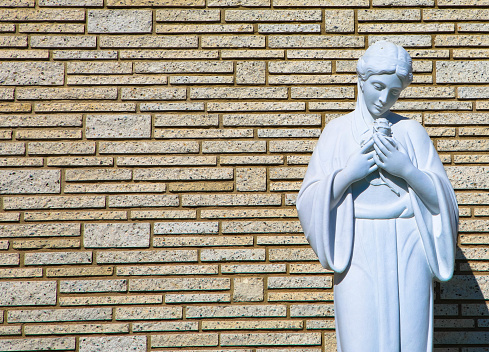 female marble statue in front of a brick wall, Forest Lawn Memorial Park, Los Angeles