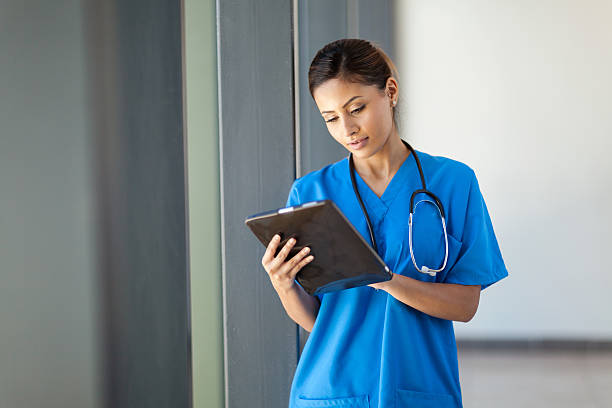 female medical nurse using tablet computer stock photo