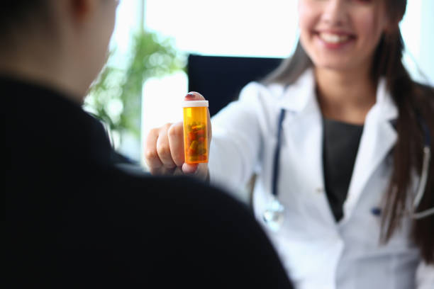 kvinnliga medicine doktor handfattning burk piller - två burkar piller bildbanksfoton och bilder