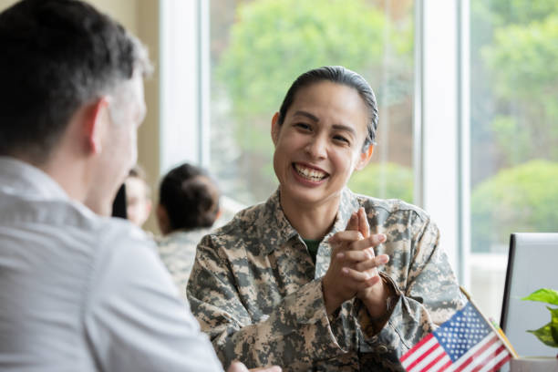 Female military recruiter smiling while discussing options with another soldier. stock photo