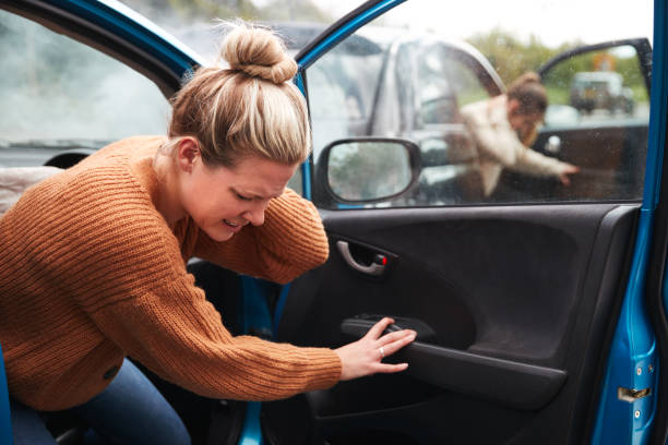 vrouwelijke automobilist in crash voor crash verzekering fraude om uit de auto - fixing car pain stockfoto's en -beelden