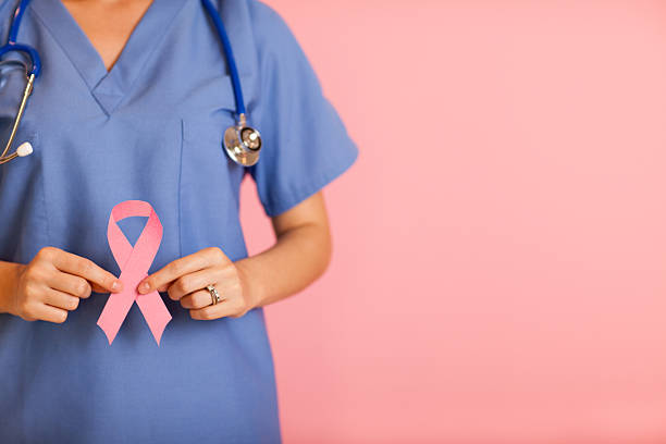 Female Nurse Holding Pink Breast Cancer Awareness Ribbon stock photo