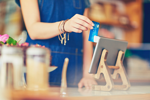 Female Owner Swiping Credit Card Using Digital Tablet In Cafe Stock Photo - Download Image Now ...