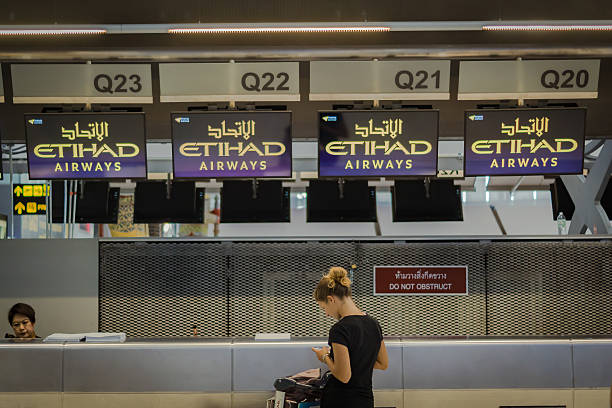 weibliche passagiere bei etihad airways check-in counte - etihad airways stock-fotos und bilder