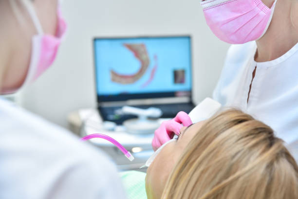 Female patient having dental scanning done by her dentist stock photo