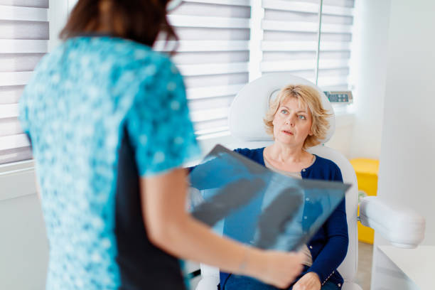 Vrouwelijke patiënt geschokt door nieuws kijken naar radioloog met röntgenfoto​​​ foto