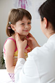 Female pediatrician checking child's throath