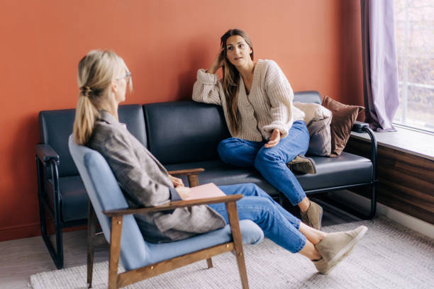 A female psychotherapist consults and gives advice and psychological support to a young woman. stock photo