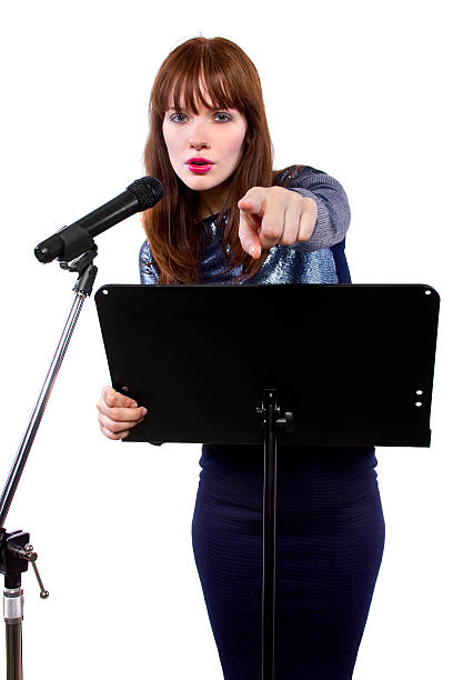 Female Public Speaker With Microphone and White Background stock photo