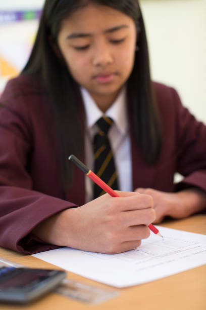 Female Pupil In Uniform Taking Multiple Choice Examination Paper Female Pupil In Uniform Taking Multiple Choice Examination Paper philippines girl stock pictures, royalty-free photos & images
