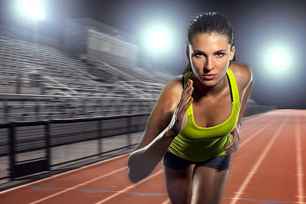 Female runner sprinter exercising training intense track field athlete sports stock photo