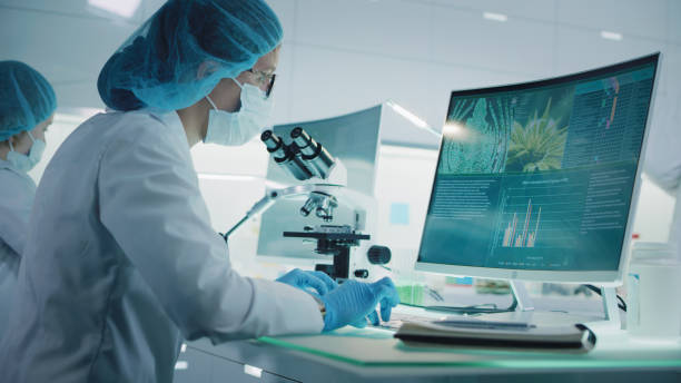 Female scientist testing medical marijuana. Charts and models on computer screens. Modern laboratory interior stock photo
