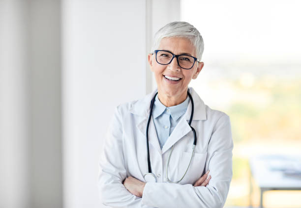 female senior doctor hospital medical clinic medicine health care portrait of a senior female doctor in a white coat with a stethoscope female doctor stock pictures, royalty-free photos & images