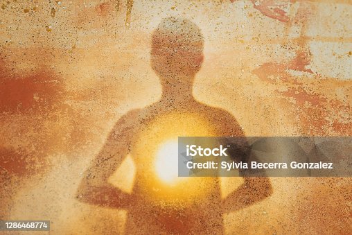 istock Female silhouette radiating light from within a spiritual heart opening 1286468774