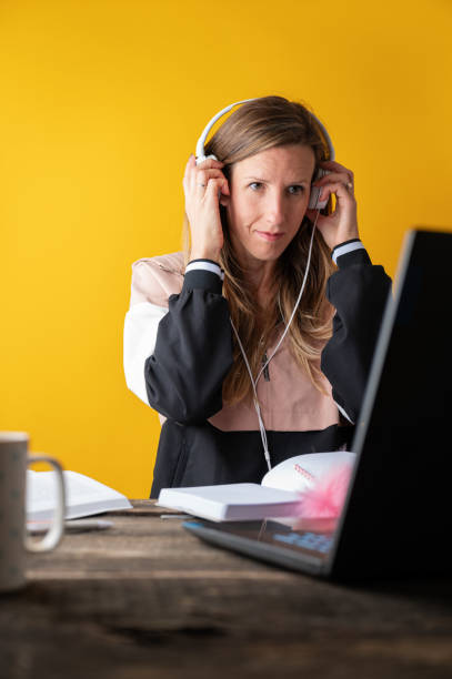 Female student with headphones listening to an online seminar stock photo