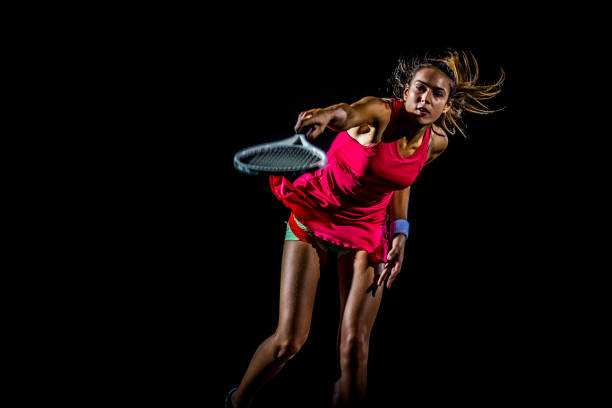Female tennis player in mid swing stock photo