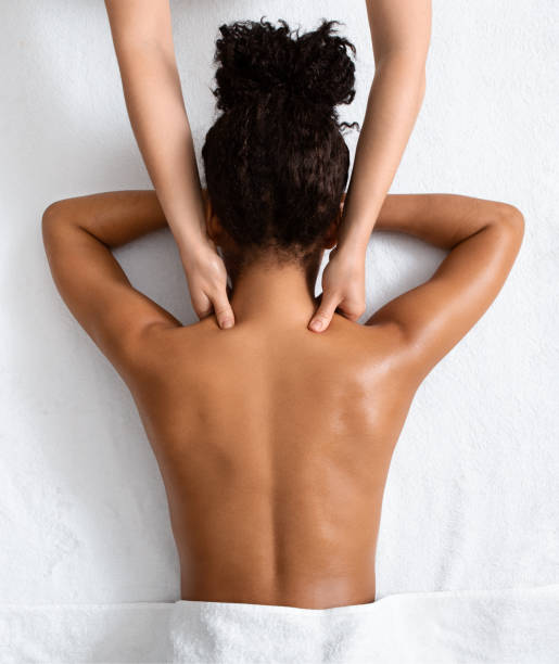 weibliche therapeutin massiert schwarzen frauenhals, ansicht von oben - masseur stock-fotos und bilder