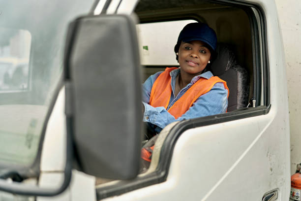 Female Truck Driver Checking Rear View Mirror stock photo