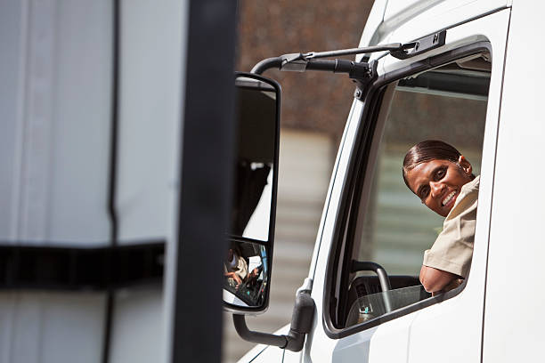 Female truck driver African American female truck driver (50s), driving semi-truck. truck driver stock pictures, royalty-free photos & images