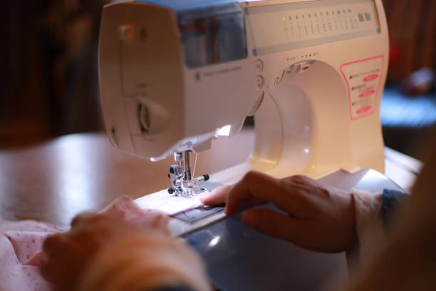 Female using a sewing machine stock photo