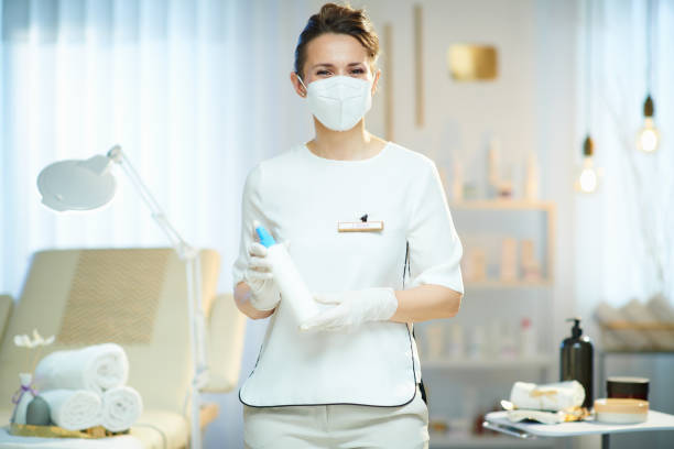female worker with ffp2 mask in modern beauty salon stock photo