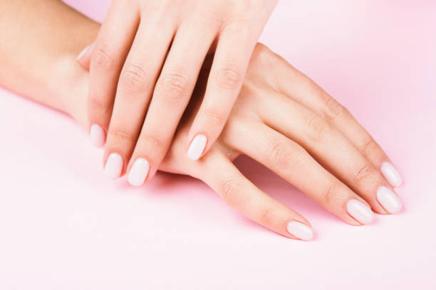 Female's hands with classic pastel manicure. Female's hands with classic pastel manicure on pink background. Beauty salon. gel pack stock pictures, royalty-free photos & images