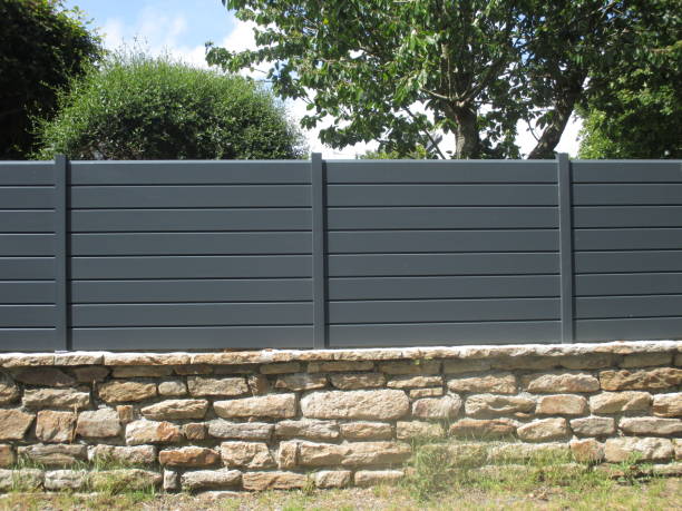 PVC fence mounted on a stone wall stock photo