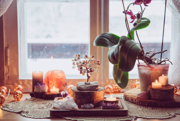 Feng Shui nature theme altar at home table and on window sill. Earth element( rock crystal clusters), wood element( wood discs), fire element( candles), rock salt candle holder. Positive home energy.  shrine stock pictures, royalty-free photos & images
