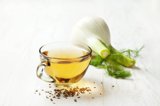 fennel tea fennel tea in a glass bowl, fresh fennel on a white wooden background fennel stock pictures, royalty-free photos & images