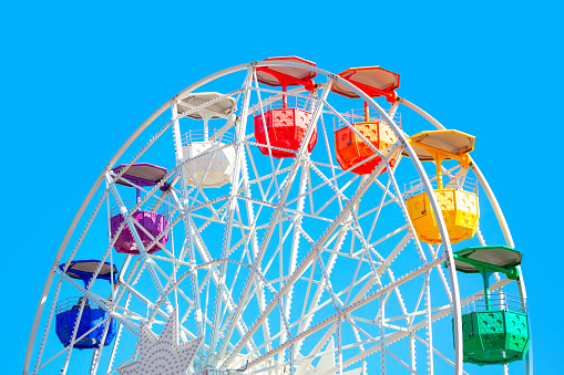 Ferris Wheel with colorful cabins . Amusement park
