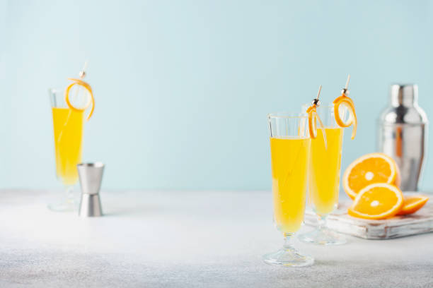Festive Alcohol cocktail Mimosa with Orange juice and cold Champagne or sparkling Wine in glasses on table. stock photo