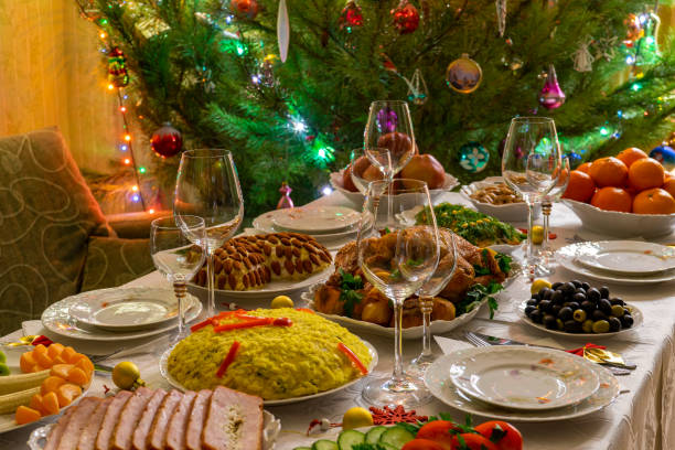 festive christmas served table against beautiful green pine tree decorated with many colorful new year toys. xmas dinner, delicious food, christmas turkey. winter holidays celebration at cozy home - new years dinner table bildbanksfoton och bilder