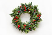 istock Festive Christmas wreath of fresh natural spruce branches with red holly berries. Traditional decoration for Xmas. 1341867273