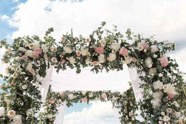 A festive chuppah decorated with fresh beautiful flowers for an outdoor wedding ceremony A festive chuppah decorated with fresh beautiful flowers for an outdoor wedding ceremony. ketubah stock pictures, royalty-free photos & images