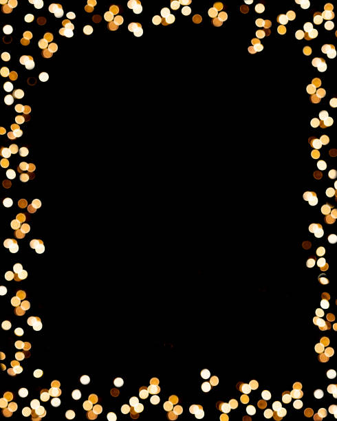 Festive frame made of a golden garland on a black background. Copy Space stock photo