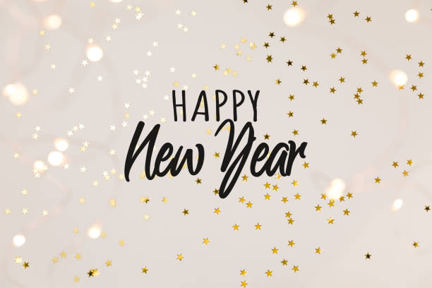 Festive gold background with Happy New Year celebration. Shining stars confetti and fairy lights on beige background. Flat lay, top view.  happy new year stock pictures, royalty-free photos & images