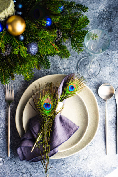 Festive table setting for Christmas dinner Festive table setting decorated with peacock feather for Christmas dinner on stone background with copy space aqua menthe photos stock pictures, royalty-free photos & images