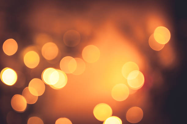 Festive warm bokeh with sparkling Christmas lights in orange colors stock photo