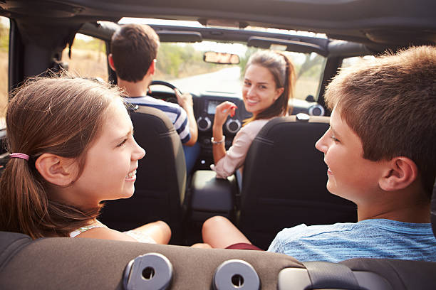 kuvapankkikuvat ja rojaltivapaat kuvat aiheesta nelihenkinen perhe autossa, poika ja tyttö puhumassa takapenkillä - vacation song