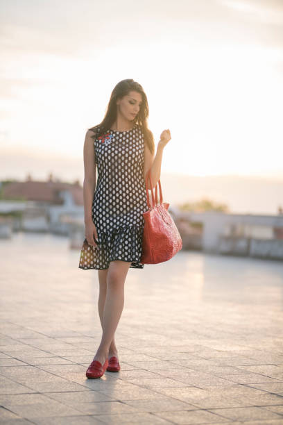 Fashion portrait of a beautiful, young woman posing, wearing dotted spring dress.