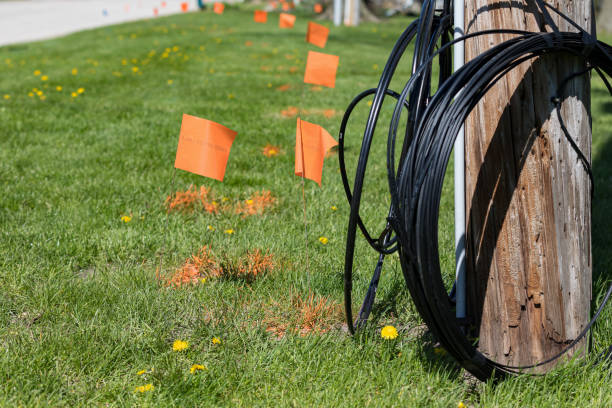 Fiber optic cable, orange marking flags and utility pole. Concept of digging safety, utility locate service and high speed internet background, no people buried stock pictures, royalty-free photos & images