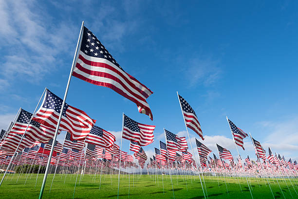 Field of American Flags A field of hundreds of American flags.  Commemorating veteran's day, memorial day or 9/11. memorial day background stock pictures, royalty-free photos & images