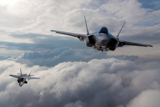 f-35 fighter jet flying over the clouds - f 35 imagens e fotografias de stock