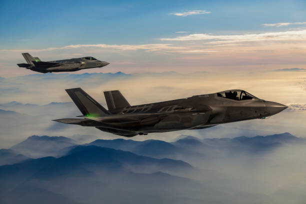 Fighter Jets flying over the fogy mountains at dusk Fighter Jets flying over the fogy mountains at dusk defense industry stock pictures, royalty-free photos & images