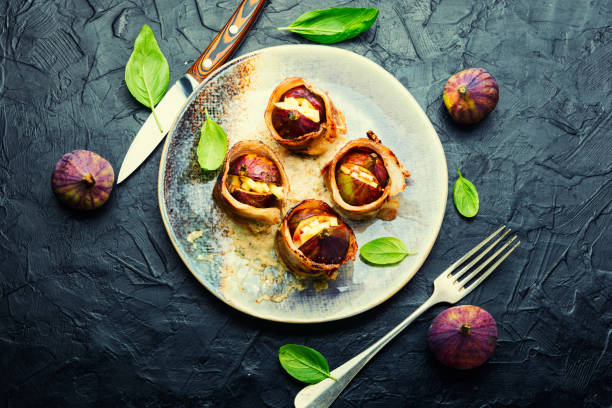 Figs roasted in bacon with cheese stock photo