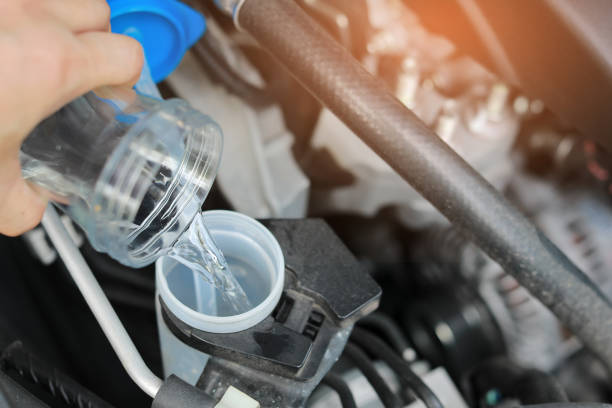 Filling the Windshield Washer Fluid in the Car. Automobile Maintenance Concept. stock photo