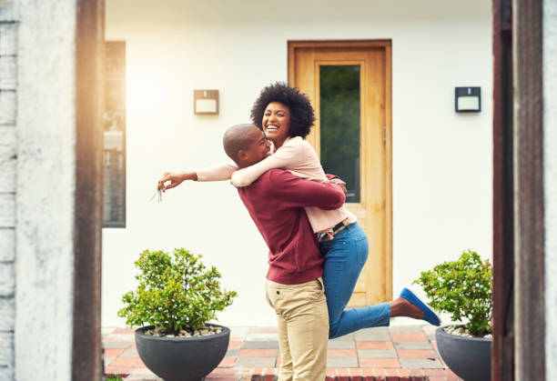 Finally a home of our own! Shot of a young couple celebrating the move into their new house moving house photos stock pictures, royalty-free photos & images